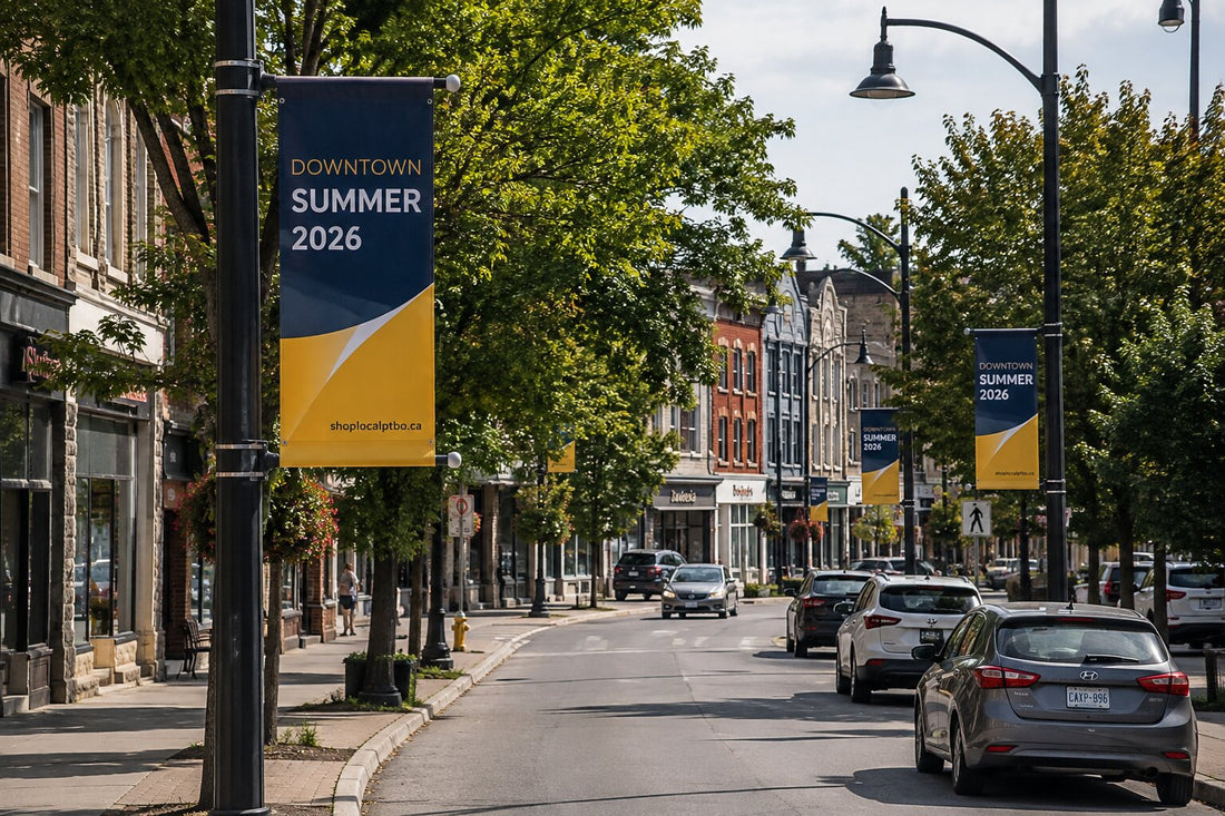 Pole banners lining a Canadian downtown street, showing banner scale against the poles and storefronts.