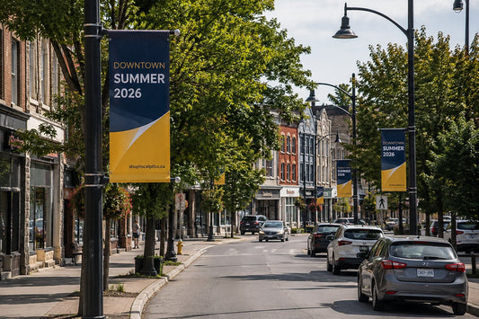 Pole banners lining a Canadian downtown street, showing banner scale against the poles and storefronts.